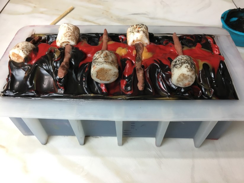 Black cold process soap with marshmallow embeds on top and fire effect