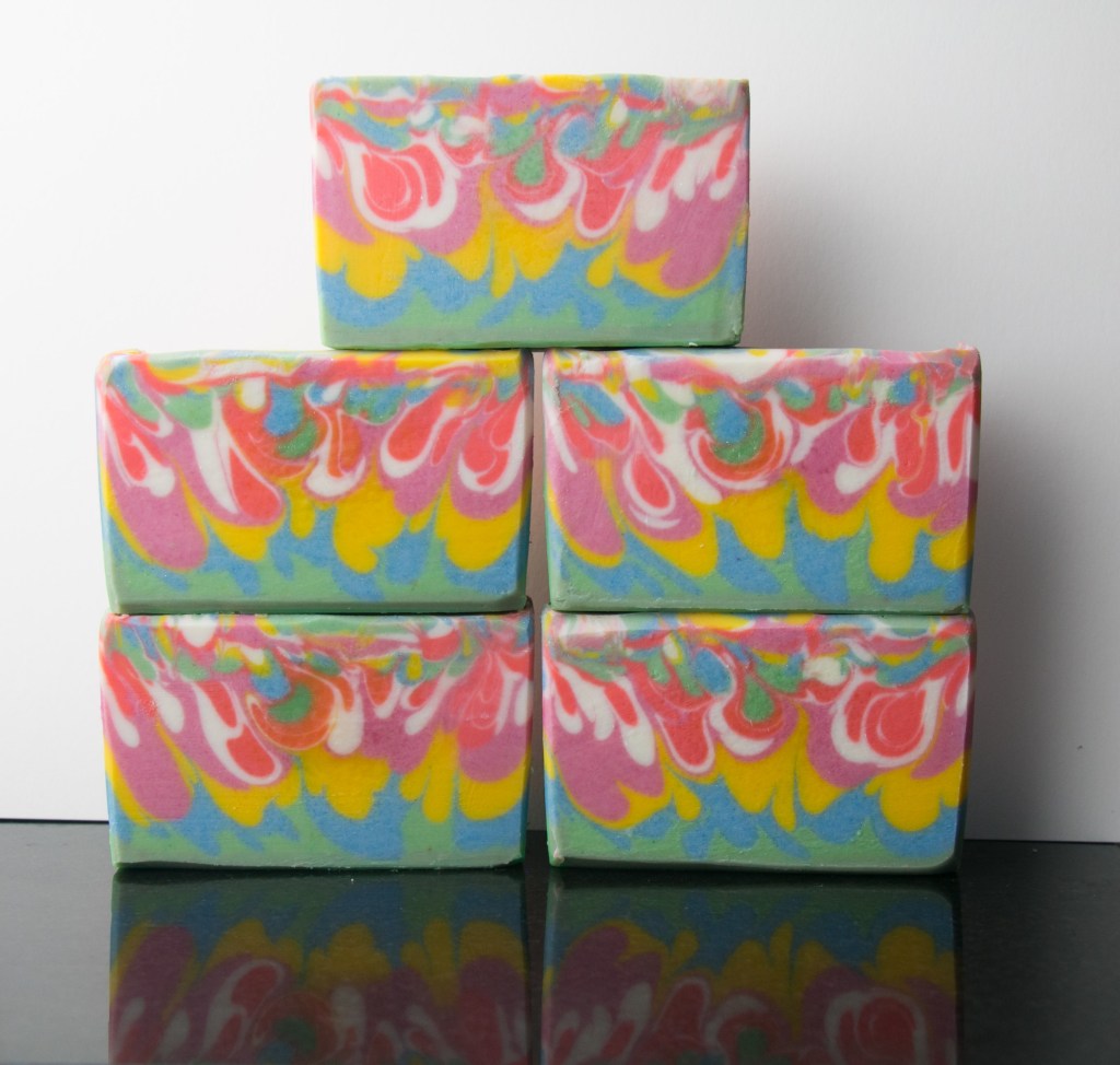 Colorful drop swirls Soaps with dark orange, pink, yellow, green and blue colors.